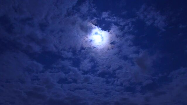 파란 밤하늘에 뜬 하얀색 달 밑으로 빠르게 지나가는 구름들 미속 촬영 영상 