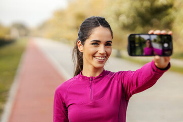 Portrait of a sportswoman taking selfie outdoors.