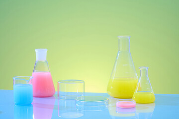 Lab theme with lab glassware and transparent podiums decorated on green gradient background. Front view, erlenmeyer flasks filled with color solution. Blank space on for product presentation