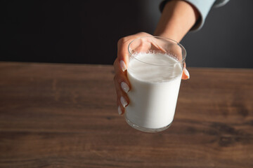 Hand holding a glass of milk.