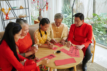 Teenage girl with parents and grandparents learning calligraphy