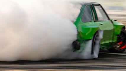 Blurred car drifting diffusion race drift car with lots of smoke from burning tires on speed track, Professional driver drifting car on race track with smoke. © Darunrat