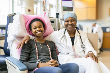 Obraz premium A smiling young patient with a healthcare professional in a hospital room, showing care and comfort during treatment.