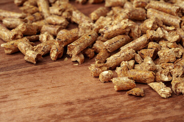 Heap of wooden pellets biofuel on wooden table