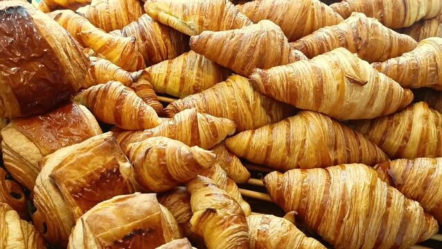Delicious baked croissants. Fresh pastries on display in the morning. Fragrant soft bread and French croissants for breakfast