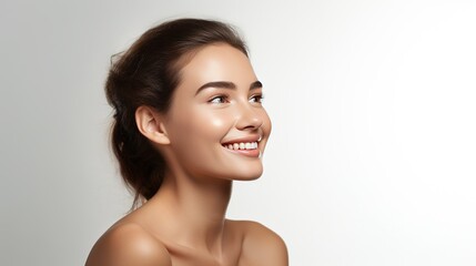Woman smiling while touching her flawless glowy skin with copy space for your advertisement, white background