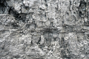 Gray wall made of coal. Coal mining area in a mine. Texture as a gray background.
