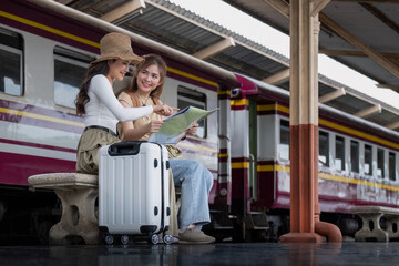 Travel concept. girl friend wear hat holding map have bag and luggage. female traveller waiting train at train station