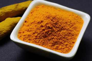 Indian Spice Turmeric powder in bowl isolated on Black background 