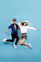 Fototapeta na wymiar Asian couple jumping for joy isolated on blue background.
