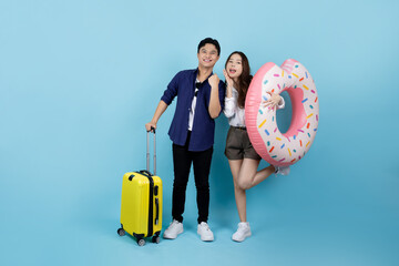 Two happy young Asian tourists in summer clothes with suitcases and pink rubber rings Passengers...