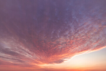 A beautiful sky tinted by the sun leaving vibrant shades of gold, pink, blue and multicolored. Clouds in the twilight evening and morning sky. Cloudy sky background in the evening and during the day.