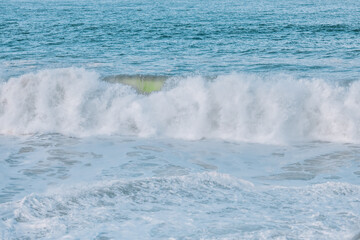 Wave splashes close-up. Crystal clear sea water hitting rock formations in the ocean in San Francisco Bay, blue water, pastel colors.