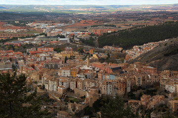 Fototapeta na wymiar Aerial view of the historic center of the city of Cuenca with colorful houses, Torre de Mangana tower and surrounding walls with the valley in the background near Madrid, Spain