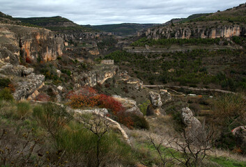 Landscape with a panoramic view of the valley and mountains with trees and bushes against a blue sky with clouds in the city of Cuenca, near Madrid, Spain