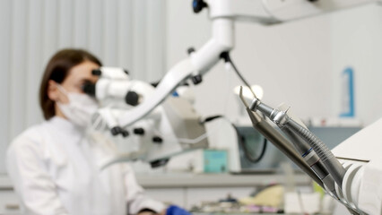 Portrait of a female dentist at work in dentistry in a white coat, busy with the work process. Concept of in-demand professions, medicine and dental services.