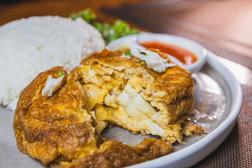 Thai street food, traditinal Thai omlete stuff minced pork for lunch time on wooden table background
