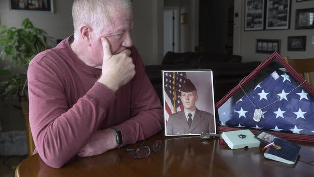 Old man grieving the loss of his military son in a foreign war