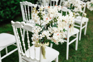  wedding chair decorated with white flowers in nature.Close-up