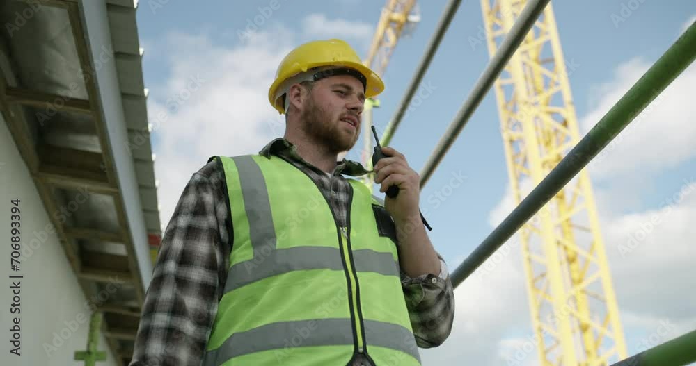 Poster Engineering, construction site and man with a walkie talkie talking for building development project. Industrial renovation, contractor or manager speaking of safety on a radio for communication