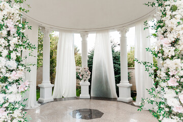 Luxurious white wedding arch decorated with flowers