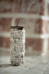 Burning incense sticks with smoke on the background of a brick wall