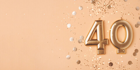 40 years celebration. Greeting banner. Gold candles in the form of number forty on peach background with confetti.