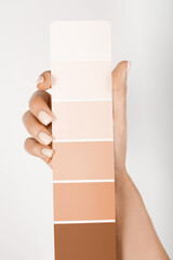 Hand holding Color samples palette design catalog. New trending PANTONE Peach Fuzz colour of 2024 year