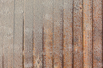 Close-up of a deck made of wooden pine planks partially covered with sand. Background. Texture.