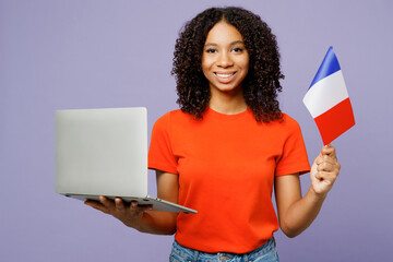 Little French student kid teen IT girl of African American ethnicity wear orange t-shirt use laptop...