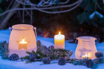 Weihnachts-Arrangement mit Laternen und Kerzenlicht am Abend im Wintergarten