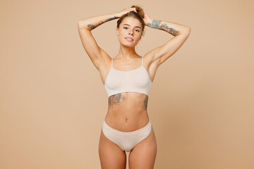 Young calm nice lady woman with slim body perfect skin wear nude top bra lingerie stand looking...