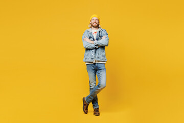 Fototapeta na wymiar Full body smiling happy confident fun young man he wears denim shirt hoody beanie hat casual clothes hold hands crossed folded isolated on plain yellow background studio portrait. Lifestyle concept.