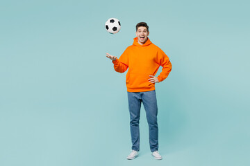 Full body young excited man fan wearing orange hoody casual clothes cheer up support football sport...