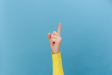 Close up of female hand pointing up demonstrating blank area on blue empty space commercial...