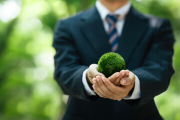 Sustainable Environment Business or Green Company concept. Business Hand Holding Green Globe to...