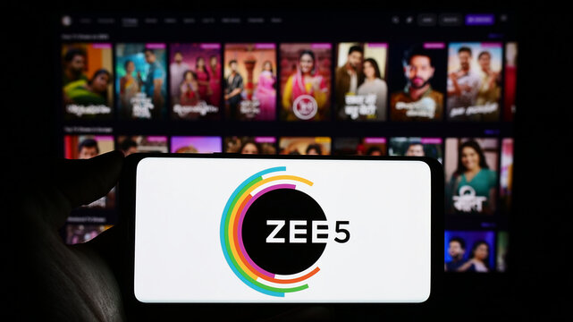 Stuttgart, Germany - 12-27-2023: Person holding cellphone with logo of Indian video streaming platform company ZEE5 in front of business web page. Focus on phone display.