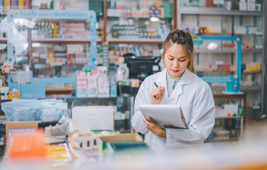 Pharmacist checking Checks Inventory of Medicine, Drugs, Vitamins with tablet and checking patient's prescription in modern pharmacy.