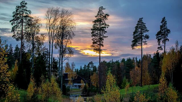 Time lapse wonderful golden hour sunset over deep forest valley log cabin in distance