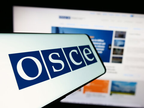 Stuttgart, Germany - 12-28-2023: Cellphone with logo of Organization for Security and Co-operation in Europe (OSCE) in front of website. Focus on center-left of phone display.