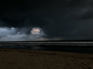 The atmosphere was cloudy and black clouds in the sky near the beach