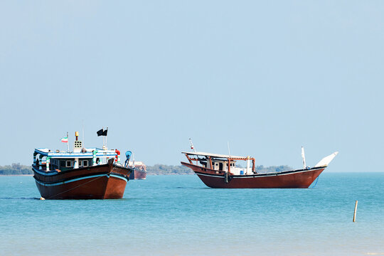 Traditional Dhow old wooden boat in the harbor of Iranian Qeshm Island. Tradition Lenj Fishing Boat in Qeshm Island in Southern Iran. Old wooden stealth smuggler's ship
