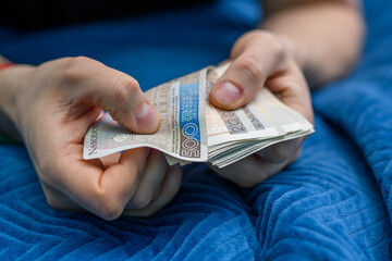 Mężczyzna liczy pieniądze, trzymać w dłoniach dużo banknotów 