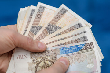 Trzymać plik polskich banknotów pln w dłoni  - obrazy, fototapety, plakaty