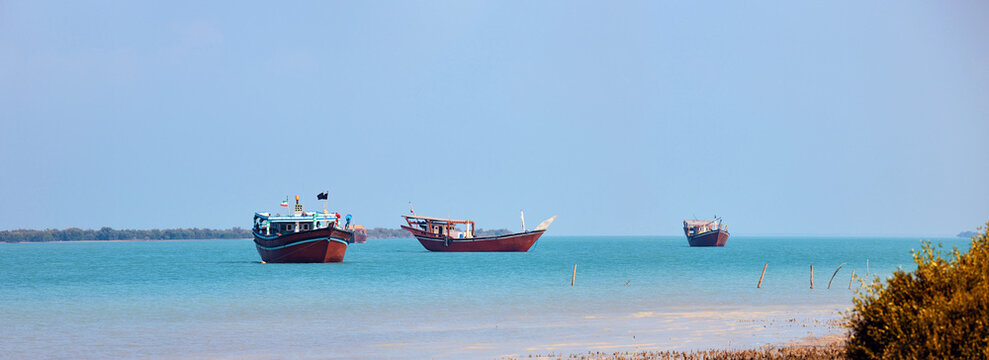 Traditional Dhow old wooden boat in the harbor of Iranian Qeshm Island. Tradition Lenj Fishing Boat in Qeshm Island in Southern Iran. Old wooden stealth smuggler's ship