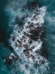 Dramatic aerial view of the waves crushing at the rock 
