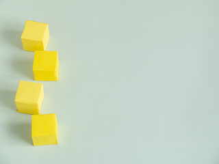 Yellow blank paper cubes on a light background