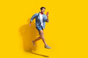Full body photo of smart man dressed denim shirt run look at smartphone enjoy fast internet...