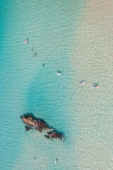 surfers waiting for a wave in crystal-clear tropical waters
