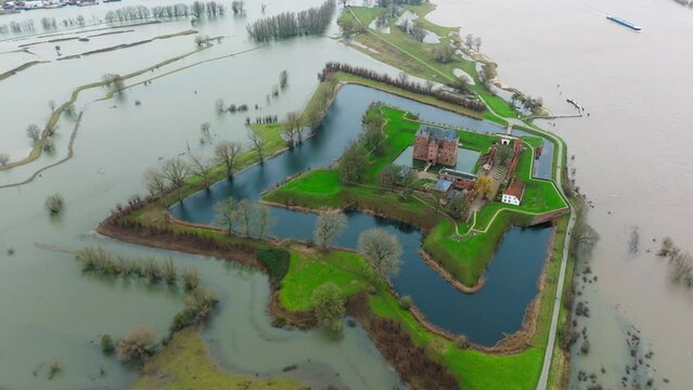 Aerial orbiting view of flooding around Lovestein Castle outside of Rotterdam as severe storms pummel the area and cause the Waal River to overrun its banks 